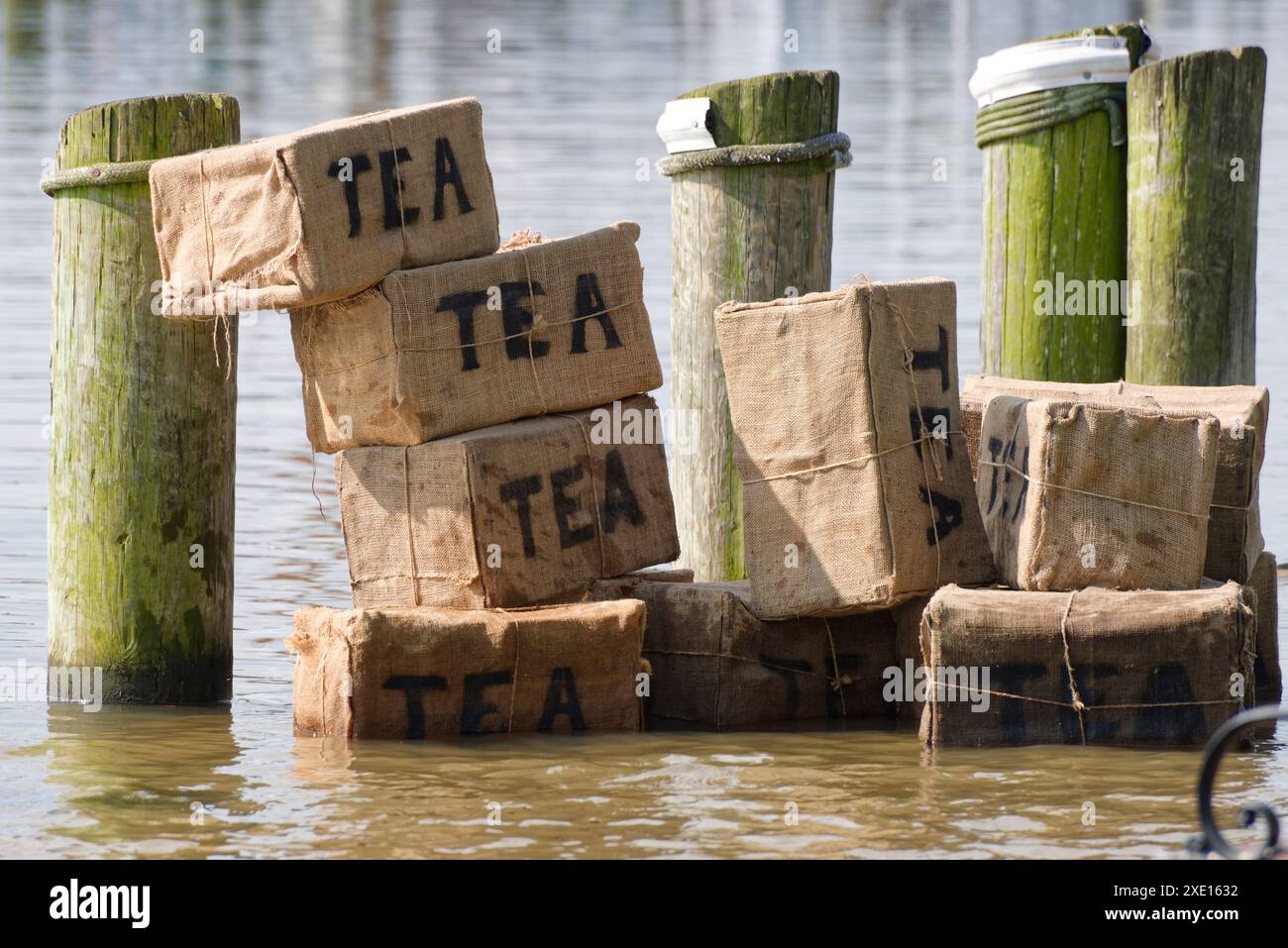 Représentation de Tea Party. Thé jeté dans l'eau. Une exposition moderne de boîtes de thé jetées dans la mer comme dans le Boston Tea Party. Banque D'Images