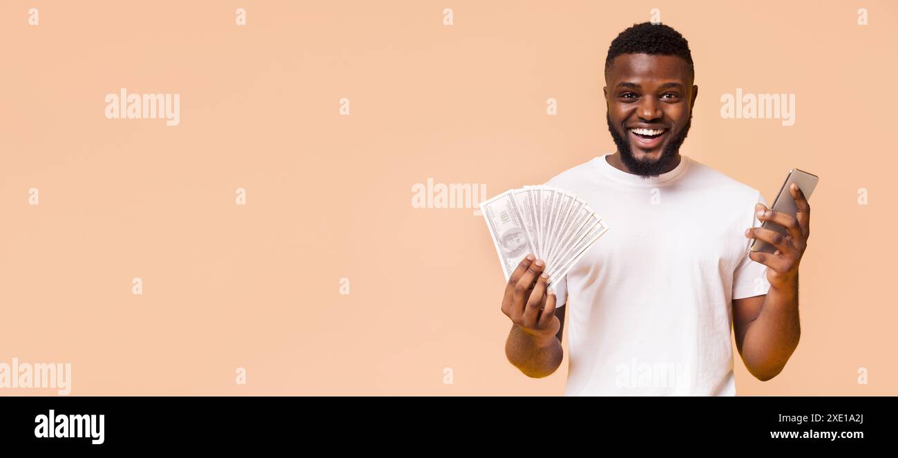 Homme heureux tenant de l'argent comptant et smartphone sur fond de pêche Banque D'Images