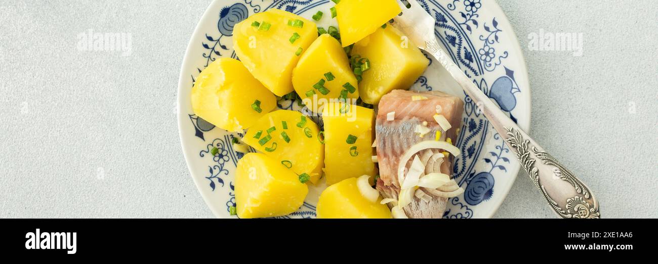 Délicieux dîners de poisson copieux, pommes de terre bouillies avec hareng mariné, vue de dessus, bannière Banque D'Images