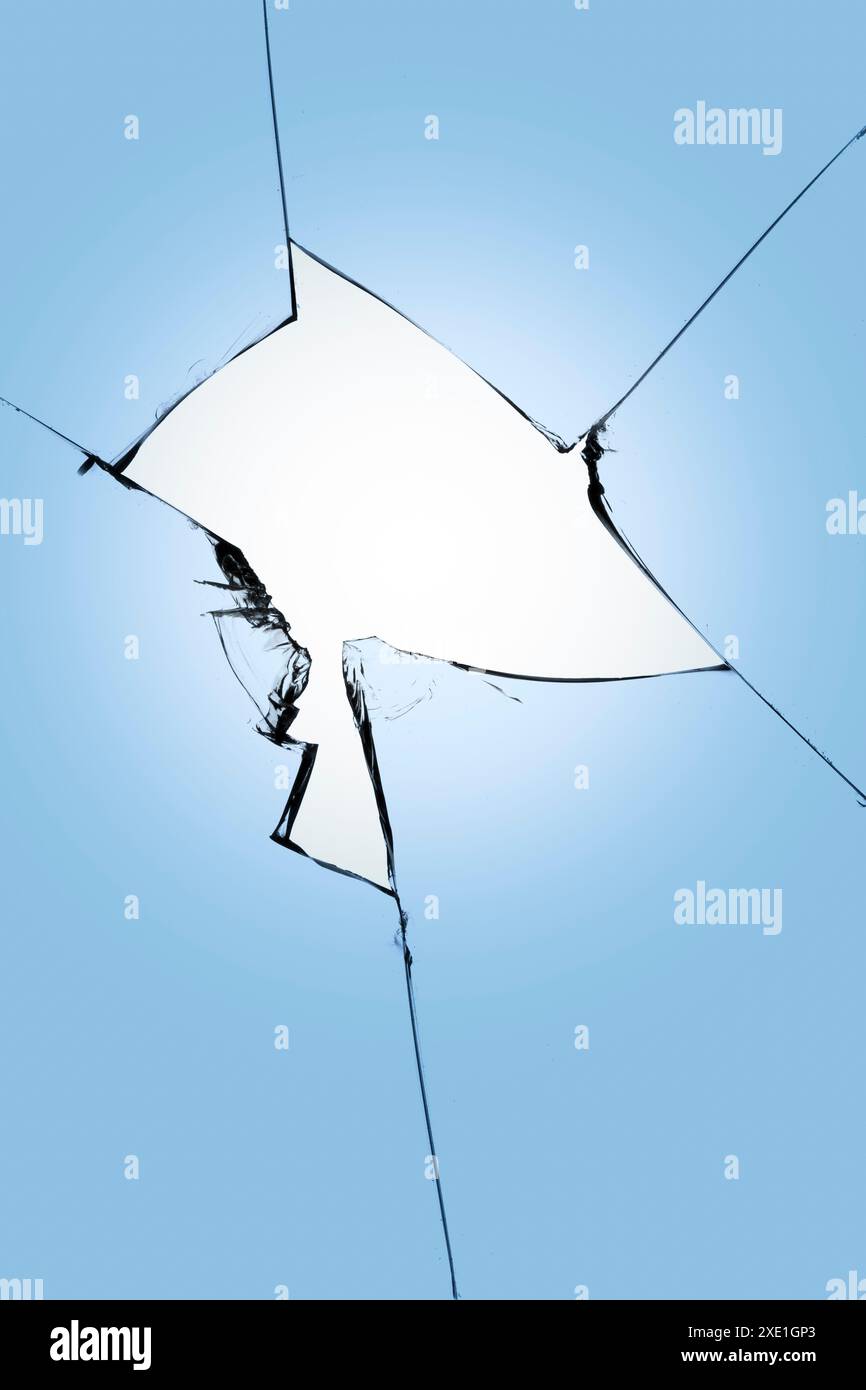 Verre brisé sur fond bleu, fissures dans le verre, fond abstrait avec un trou au centre. Banque D'Images
