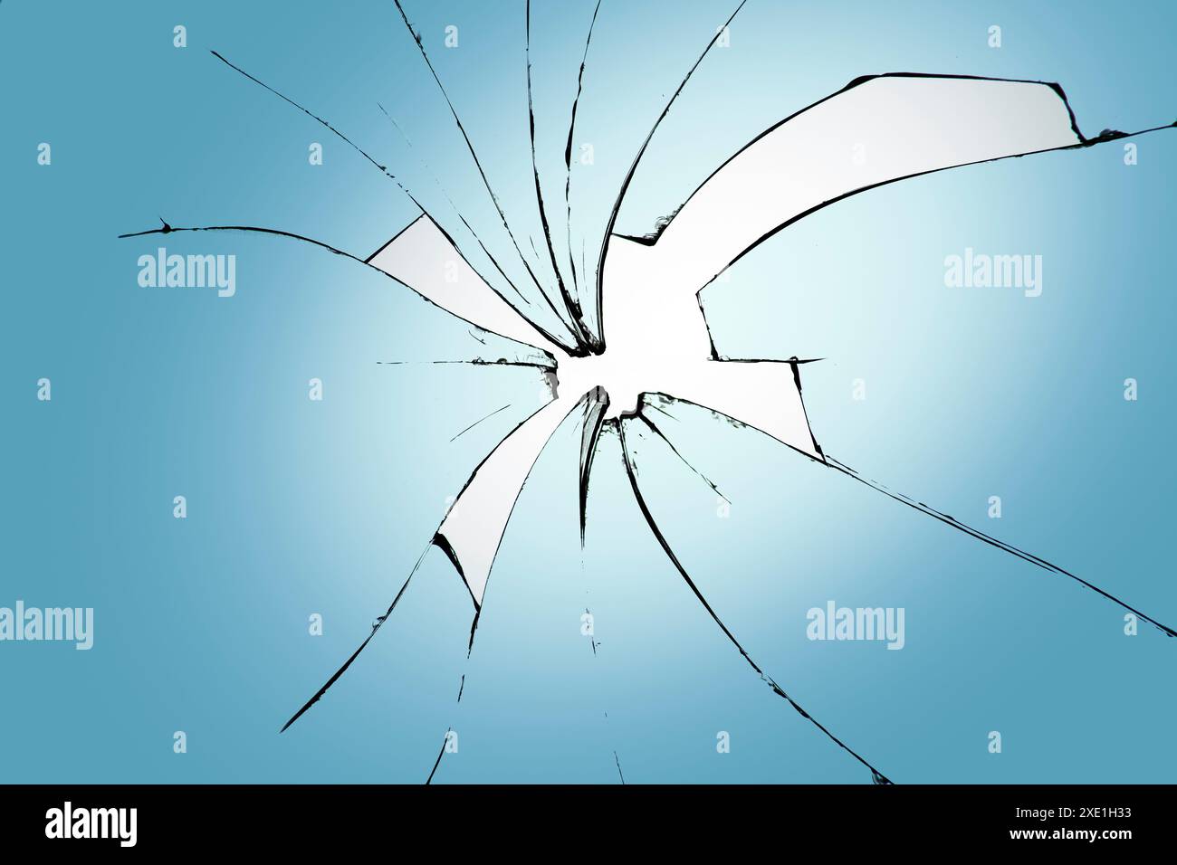 Verre brisé sur fond bleu, fissures dans le verre, fond abstrait avec un trou au centre. Banque D'Images