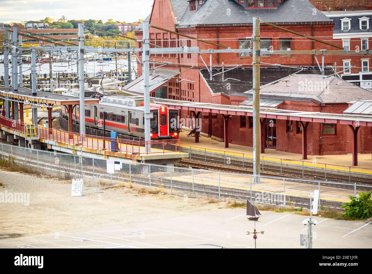 Train électrique tirant dans une ancienne gare de briques par un jour ensoleillé d'automne Banque D'Images Train électrique tirant dans une ancienne gare de briques par un jour ensoleillé d'automne Banque D'Images
