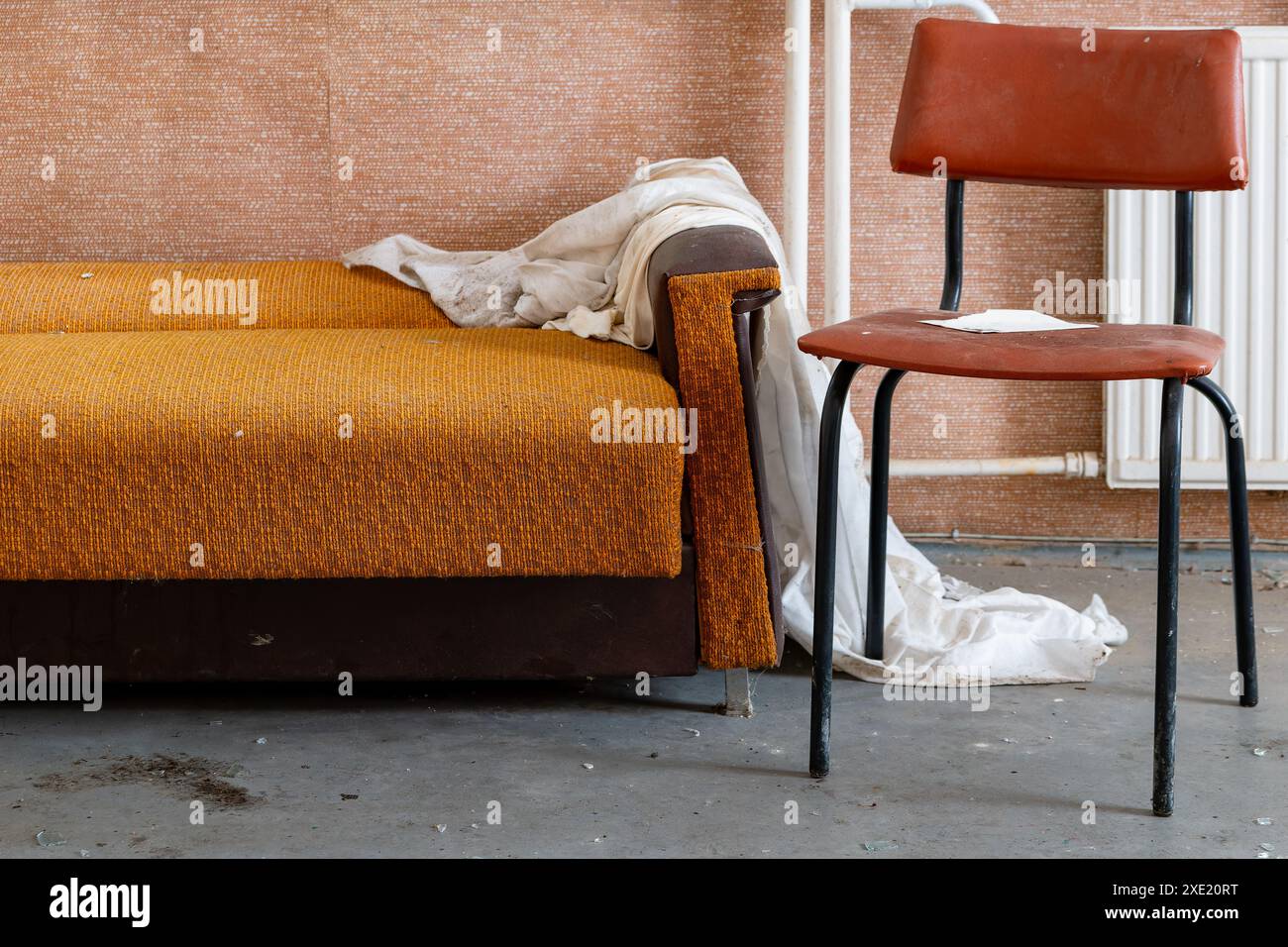 Vieux canapé avec chaise dans une maison abandonnée Banque D'Images