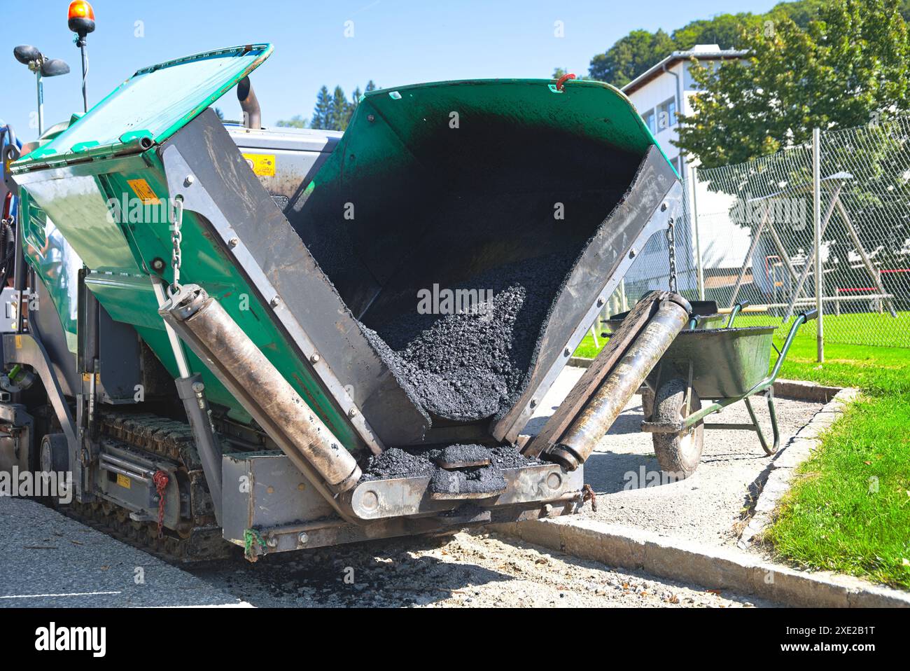Ouvrier de construction avec finisseur d'asphalte lors du pavage d'asphalte - finisseur de route de machine spéciale Banque D'Images