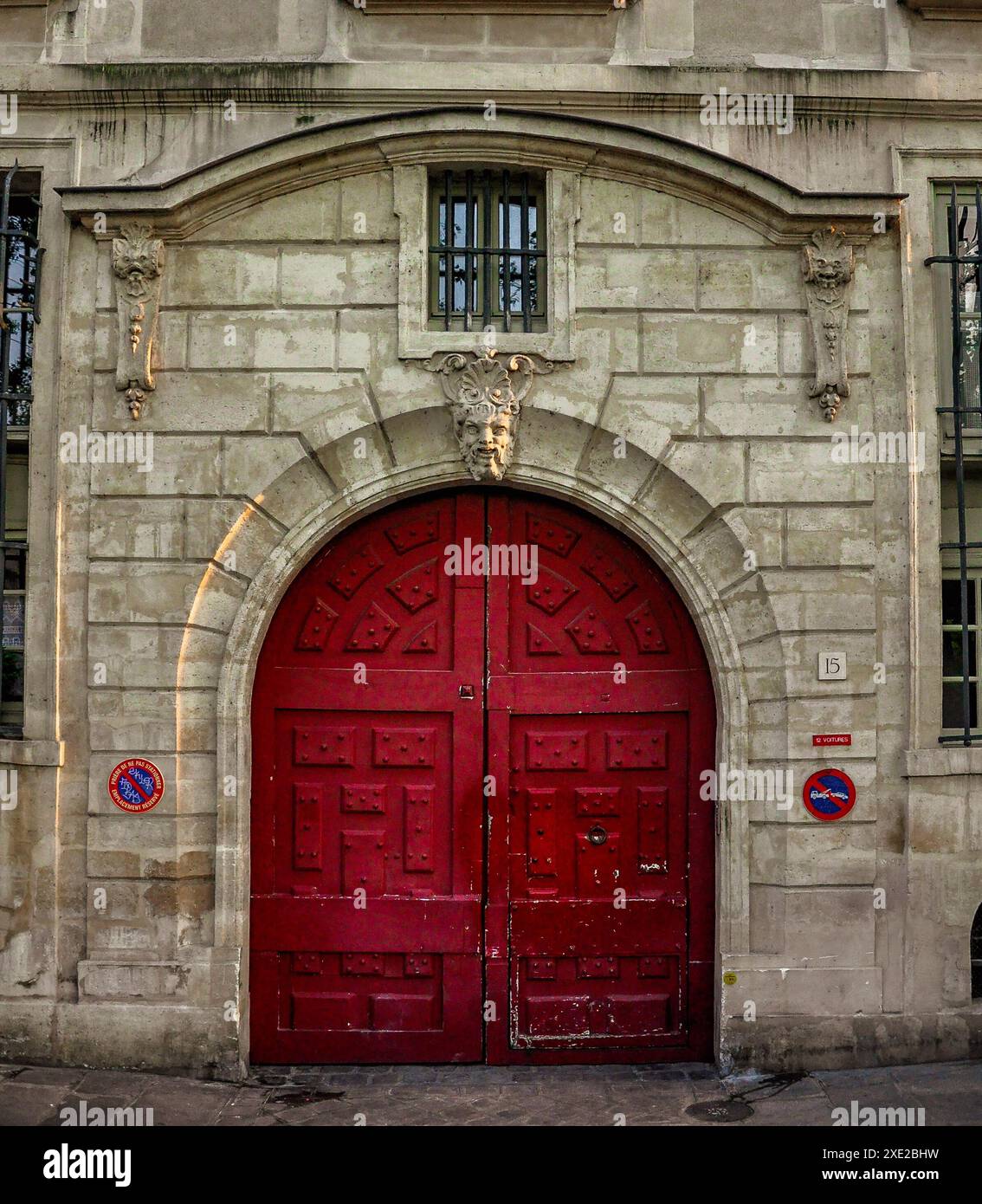 Hôtel le Charron avec porte en bois rouge vintage à Paris, porte en bois rouge vintage typique avec un relief d'un animal fantastique Banque D'Images