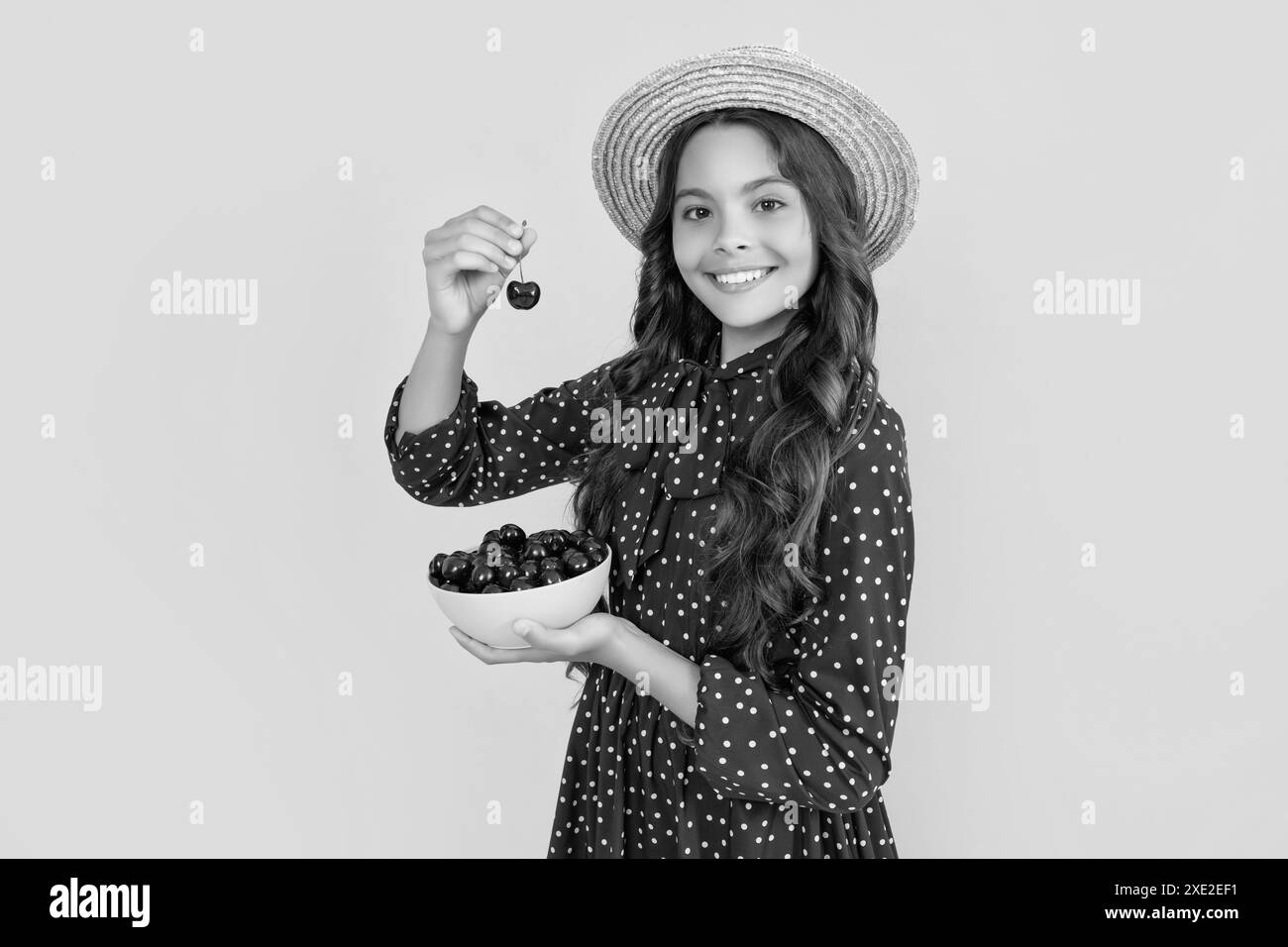 joyeux adolescent tenant des baies de cerise sur fond jaune Banque D'Images