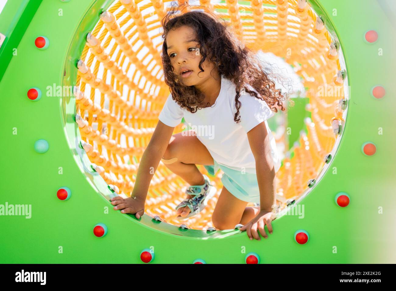 petite fille mulâtre joue dans une ville pour enfants. Photo de haute qualité Banque D'Images