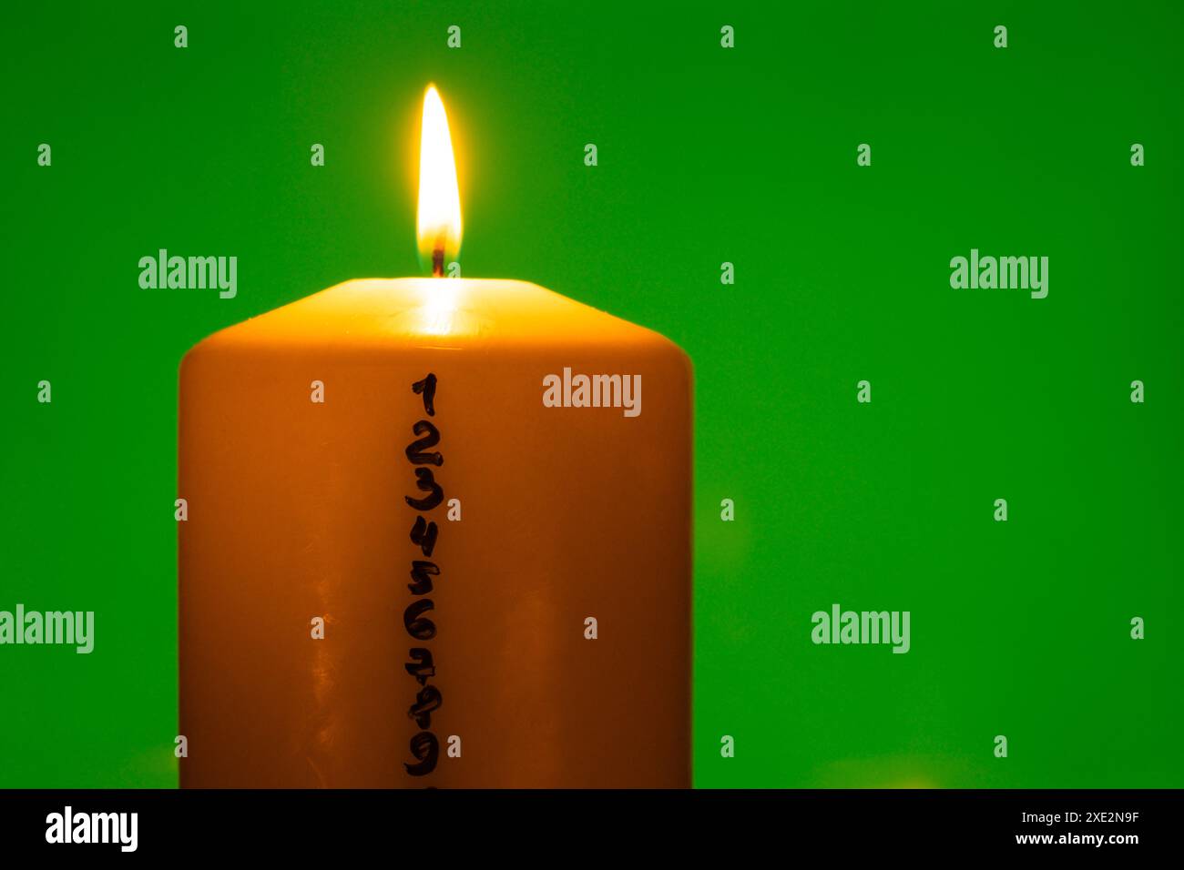 Bougie avec calendrier de l'Avent sur fond de clé chroma vert bougies de cire de Noël brûlantes traditionnelles avec des nombres à rebours Banque D'Images