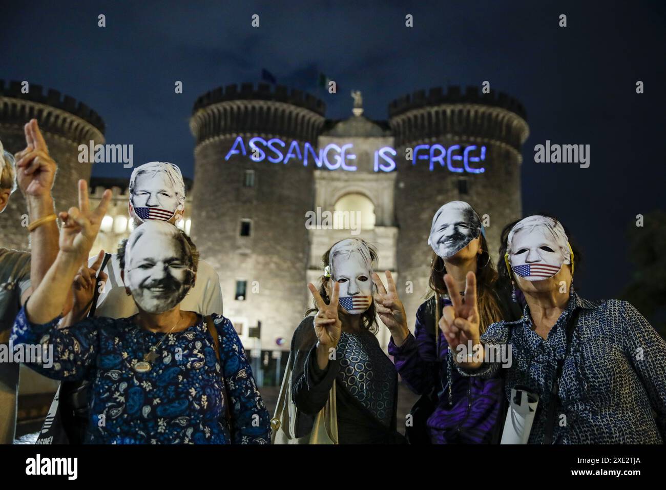 Naples : un groupe de militants libres de Julian Assange se réunit devant le château de Malé Angioino, projetant Assange est libre sur la façade pour célébrer et porter un toast après sa libération Banque D'Images