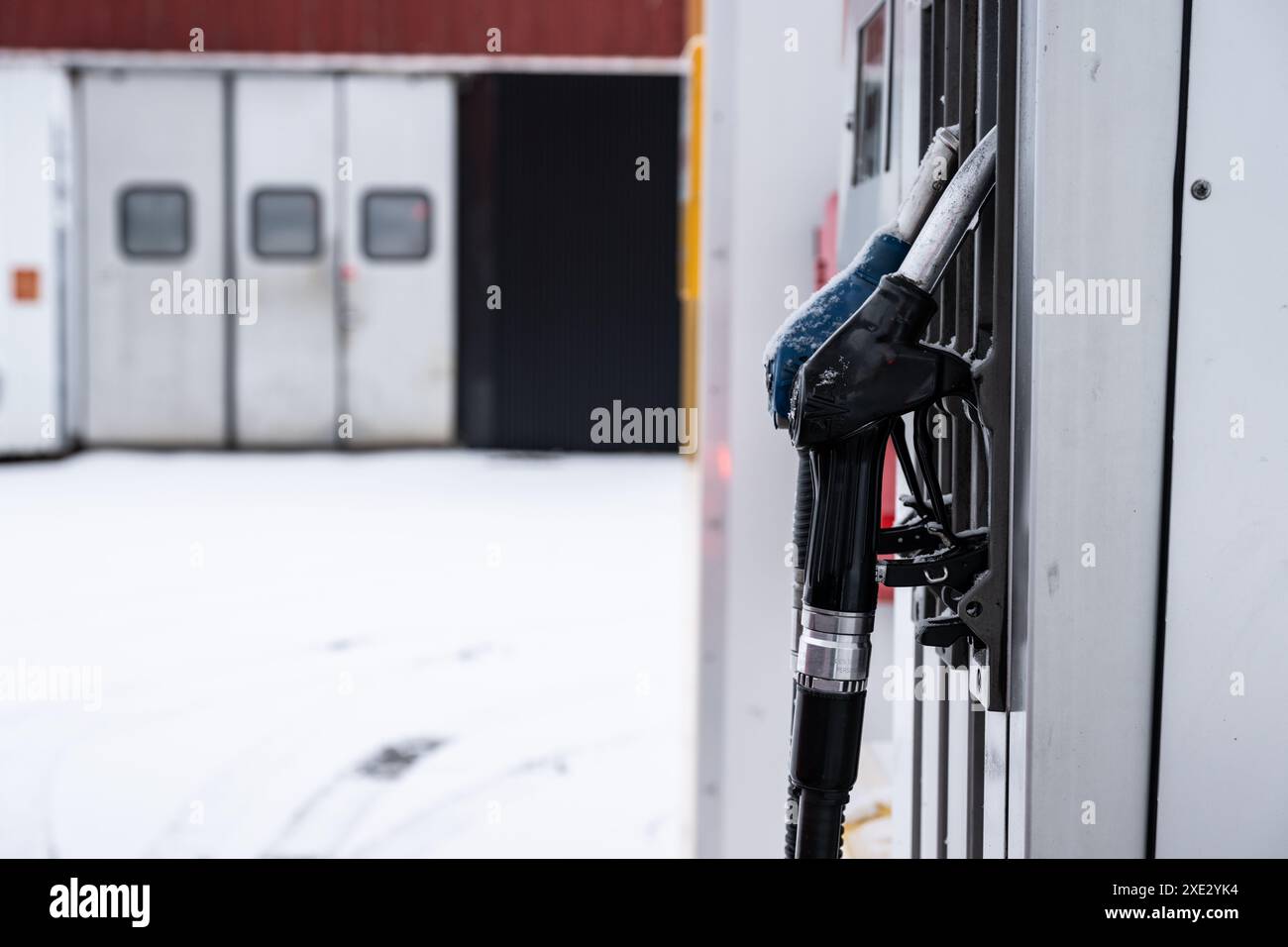 Poignées de pompe à essence dans une station-service en hiver Banque D'Images