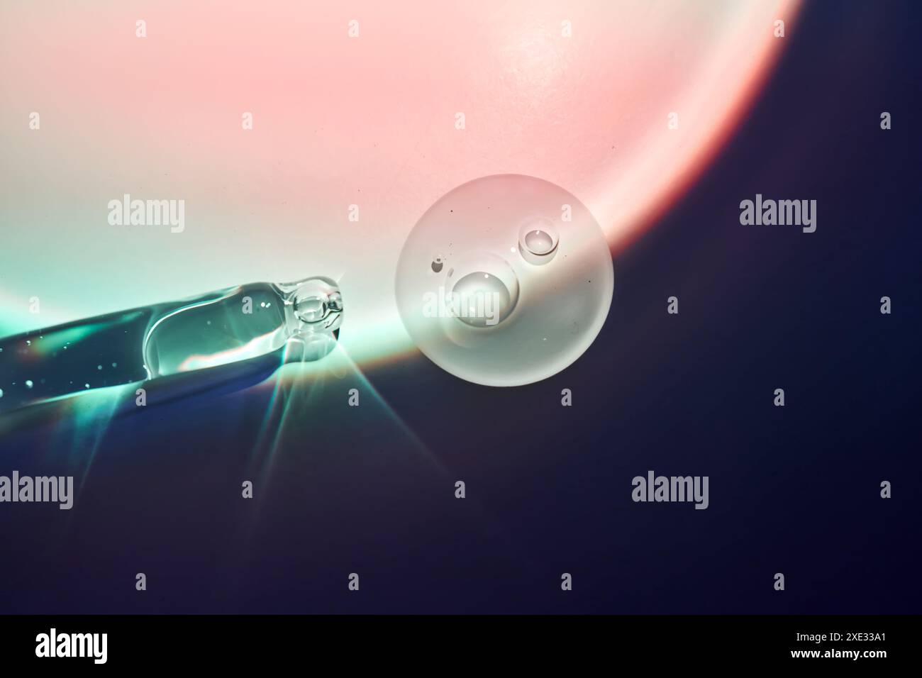 Une goutte de sérum pour le visage à la frontière de la lumière et de l'ombre. Banque D'Images
