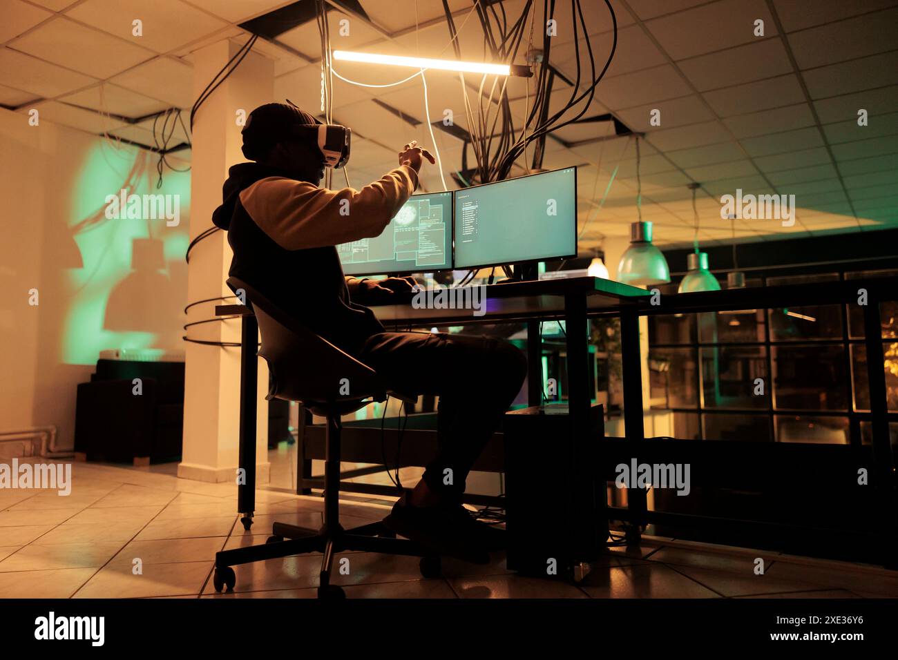 Criminel en ligne utilisant plusieurs moniteurs et lunettes vr pour craquer le cryptage et voler des mots de passe. Homme essayant de pirater le réseau informatique et le système, travaillant avec un casque de réalité virtuelle. Banque D'Images