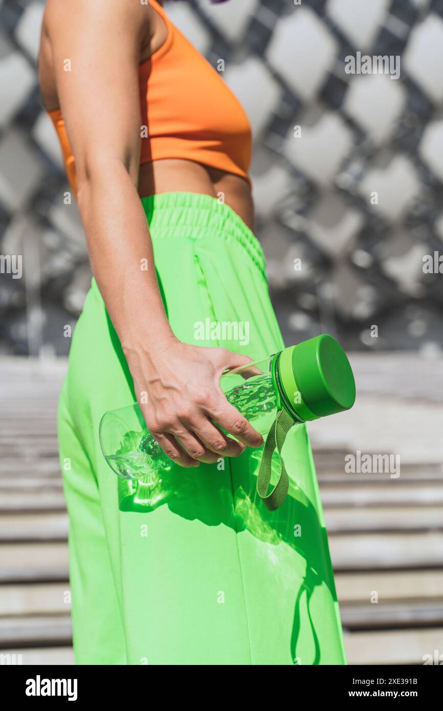 Mains féminines avec bouteille d'eau verte réutilisable Banque D'Images