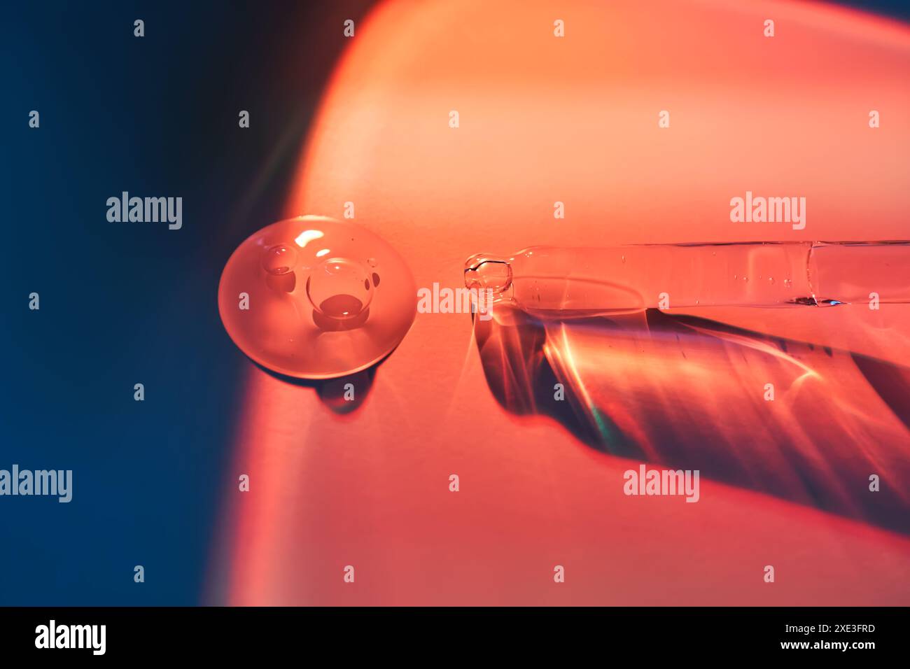 Une goutte de sérum pour le visage à la frontière de la lumière et de l'ombre. Banque D'Images