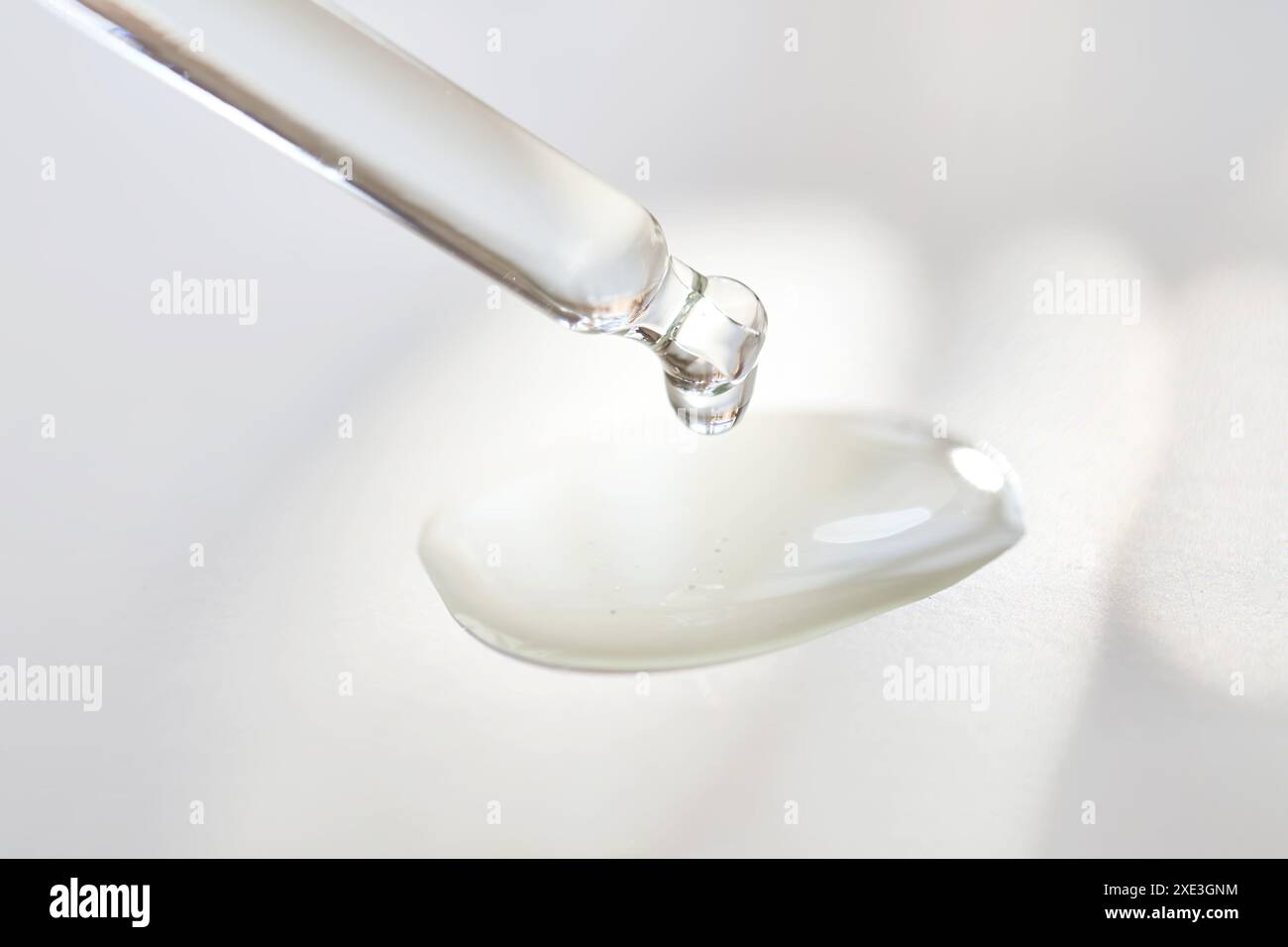 Pipette avec parfum dans un rayon de soleil. Banque D'Images