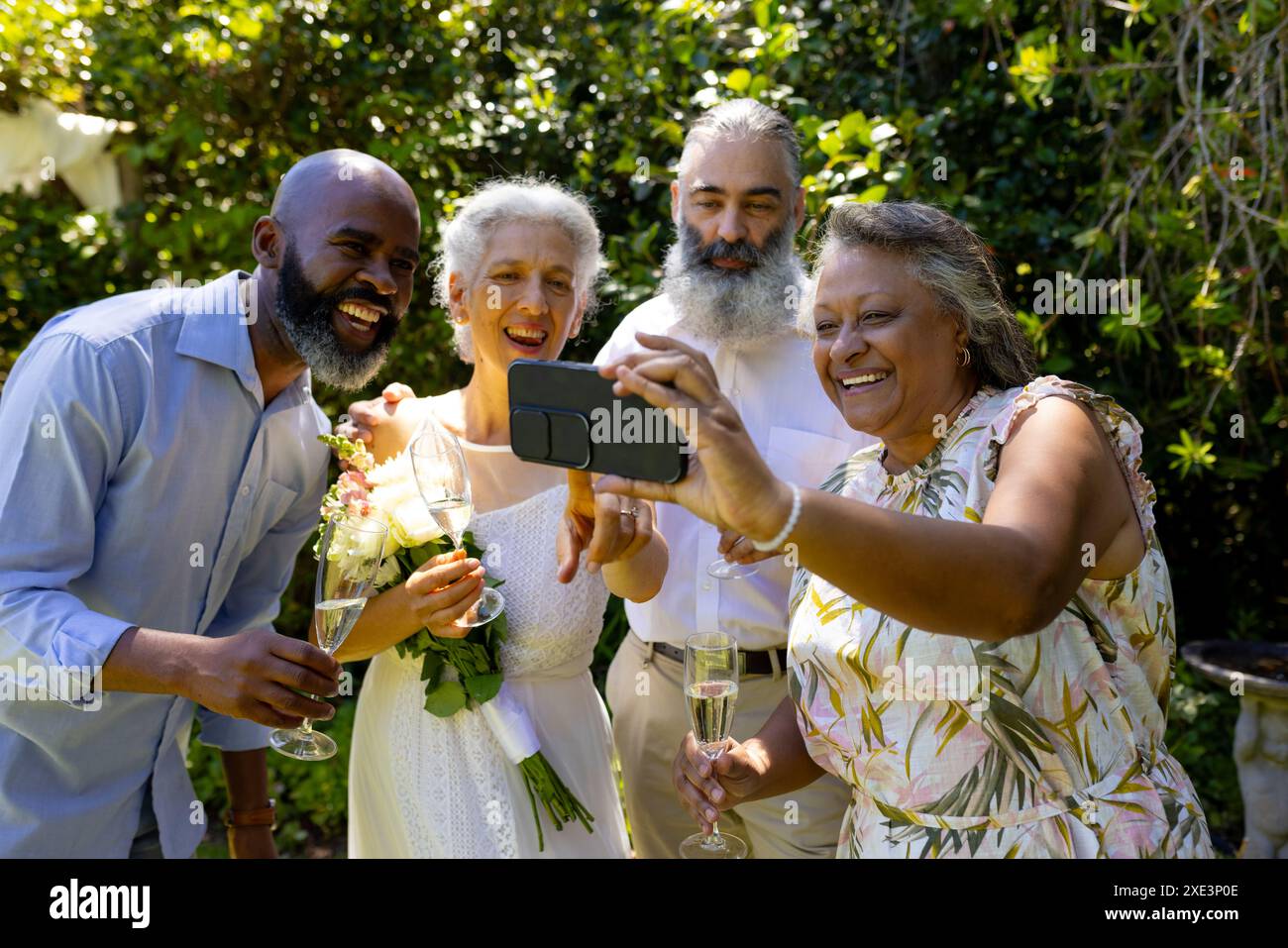 Groupe d'amis prenant selfie et célébrant avec champagne en plein air Banque D'Images