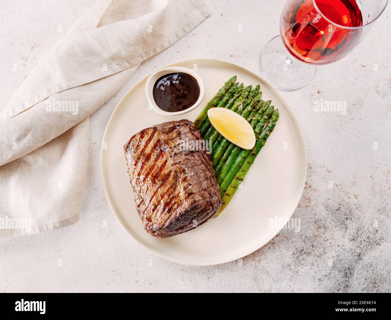 Steak de viande grillé sur assiette avec citron et asperges Banque D'Images