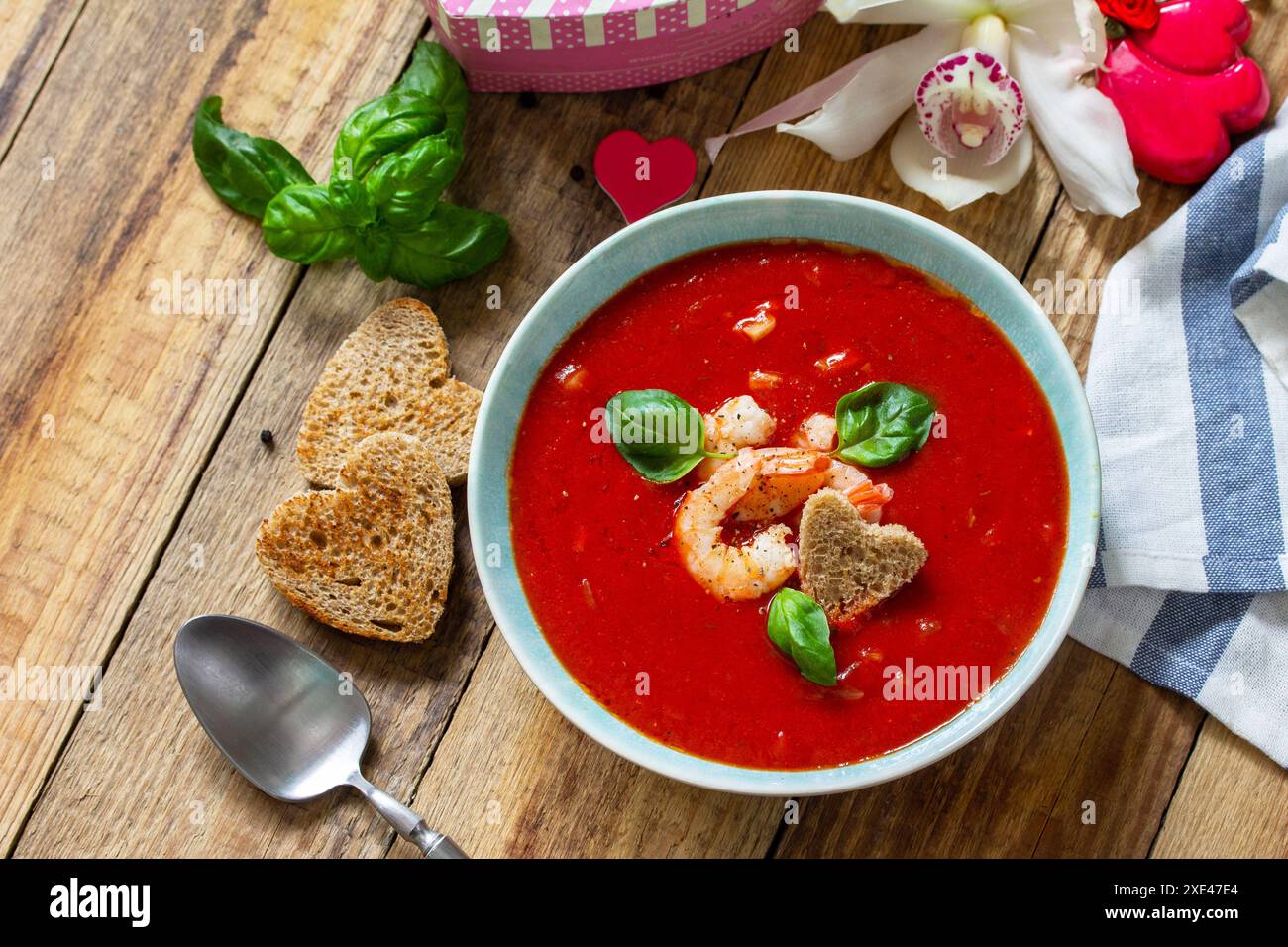 Soupe de Saint-Valentin maison, cuisine festive. Gazpacho de purée de soupe de tomates avec tomates servies fruits de mer sur une table en bois rustique. Copier sp Banque D'Images