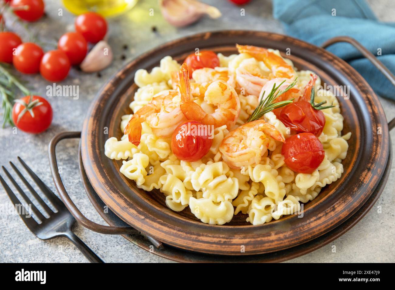 Cuisine méditerranéenne, alimentation de fruits de mer. Pâtes italiennes crème di gallo aux crevettes grillées et aux tomates sur un plateau en pierre. Banque D'Images