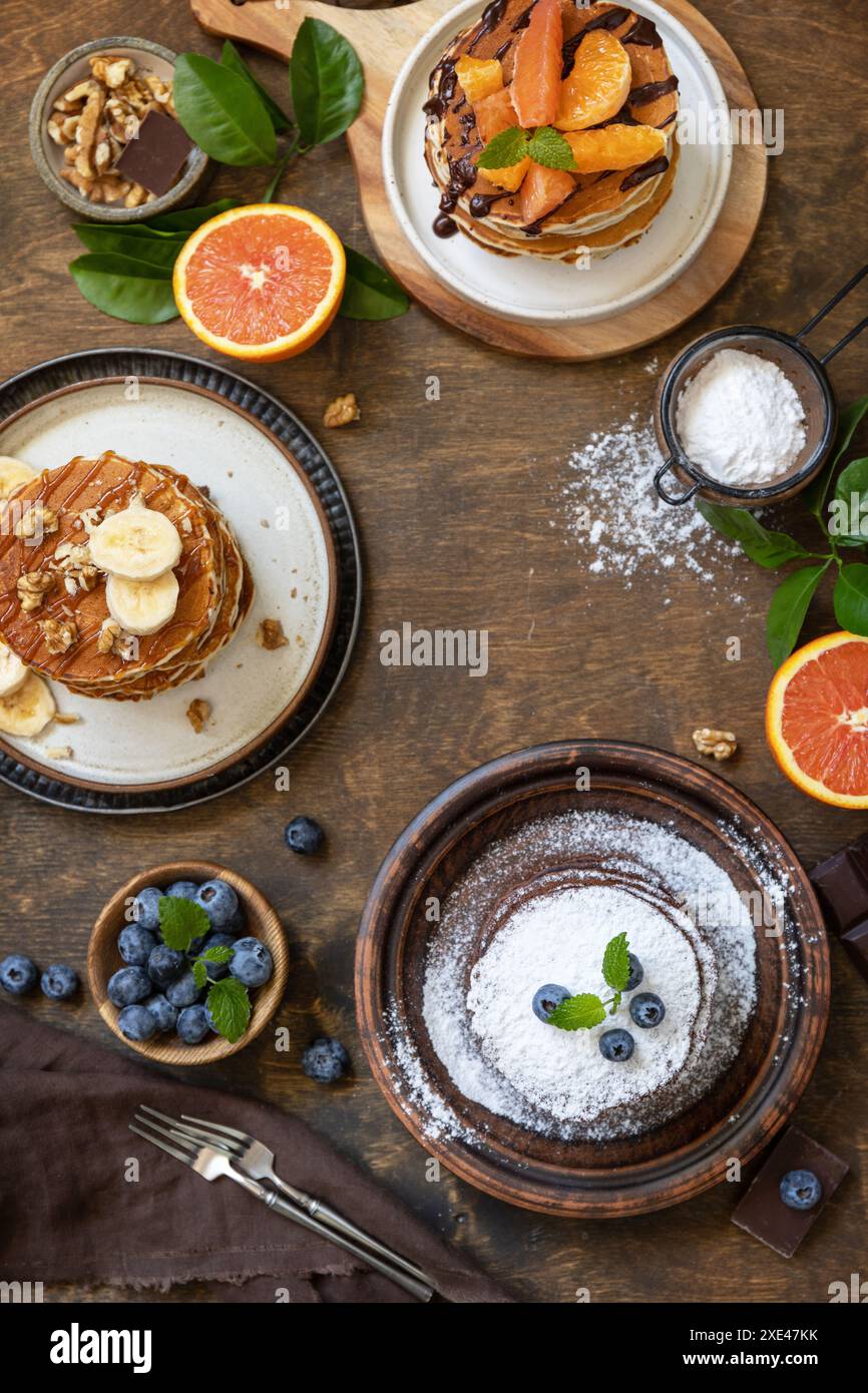 Célébration de la journée des crêpes, petit déjeuner sain. Délicieuses crêpes de bananes américaines maison avec myrtilles, noix, caramel, chocol Banque D'Images