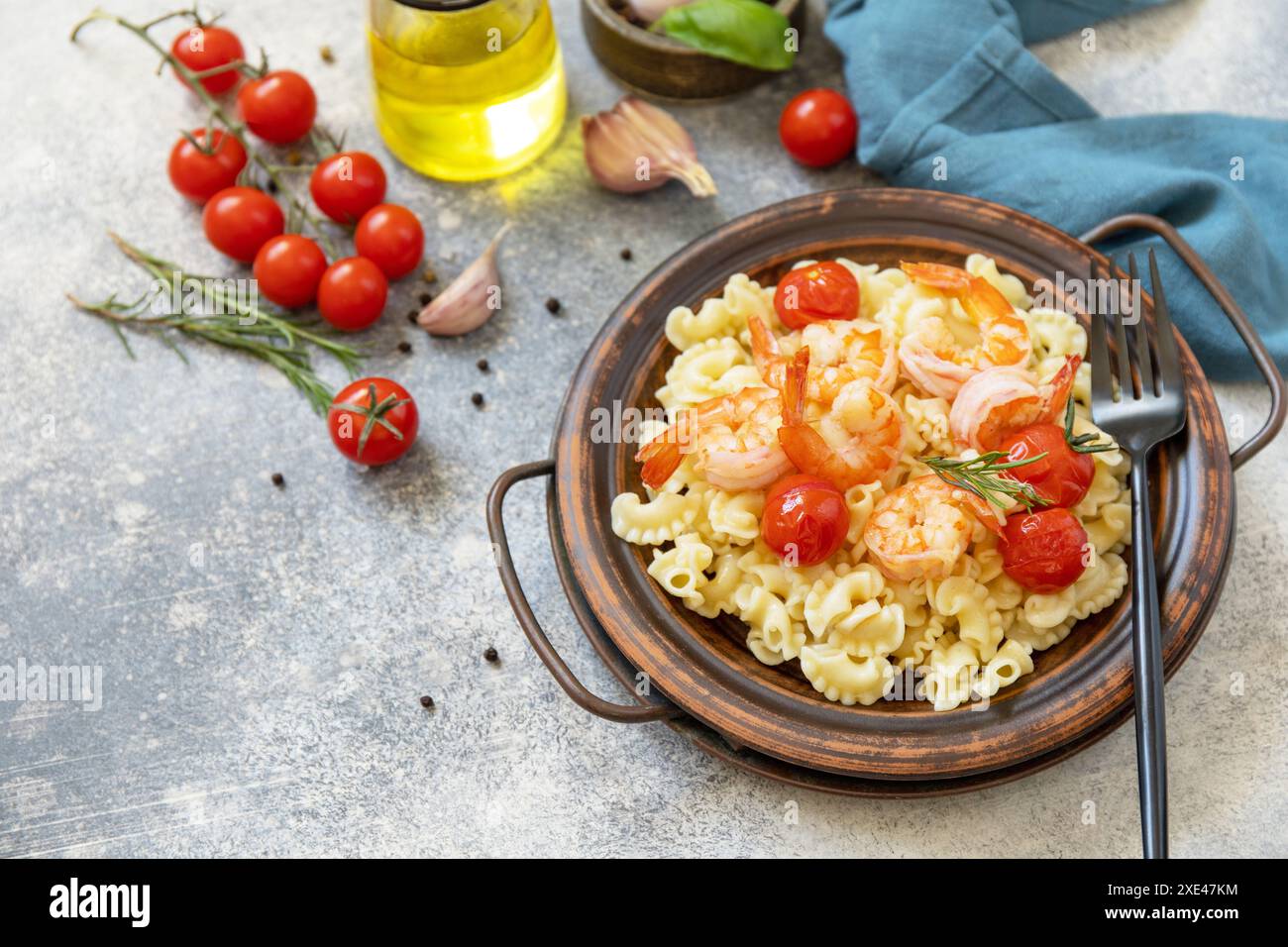 Cuisine méditerranéenne, régime de fruits de mer. Pâtes italiennes Creste di gallo avec crevettes grillées et tomates sur une table en pierre. Copier sp Banque D'Images