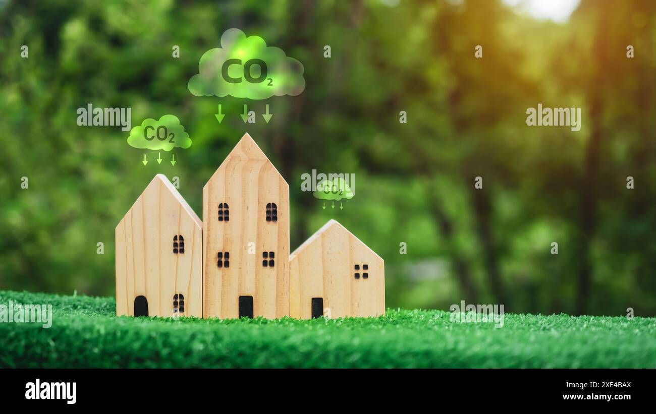 Environnement propre, concept de protection de l'environnement, Un modèle de maison en bois sur fond vert et une icône de symbole de réduction de dioxyde de carbone, carbone CRE Banque D'Images