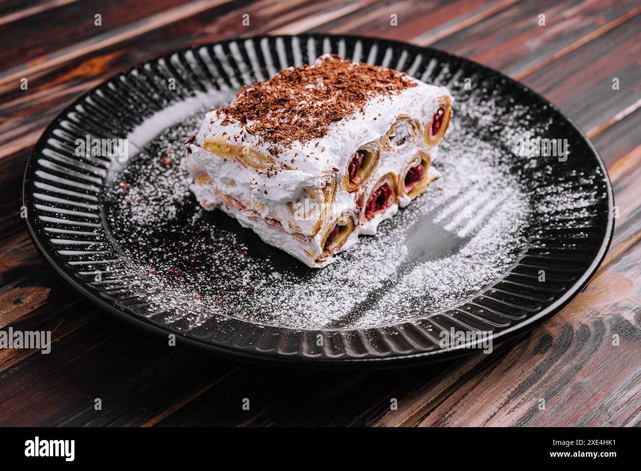 Trancher le gâteau forestier sur l'assiette noire Banque D'Images