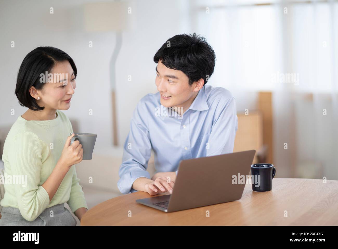 Couple regardant un ordinateur portable dans le salon Banque D'Images