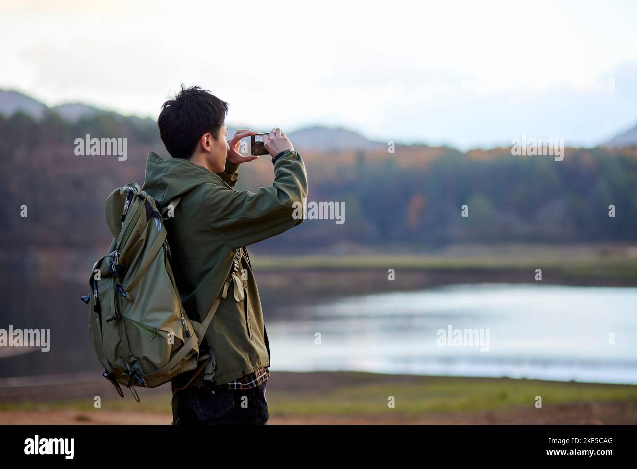 Jeune japonais prenant des photos avec son smartphone Banque D'Images