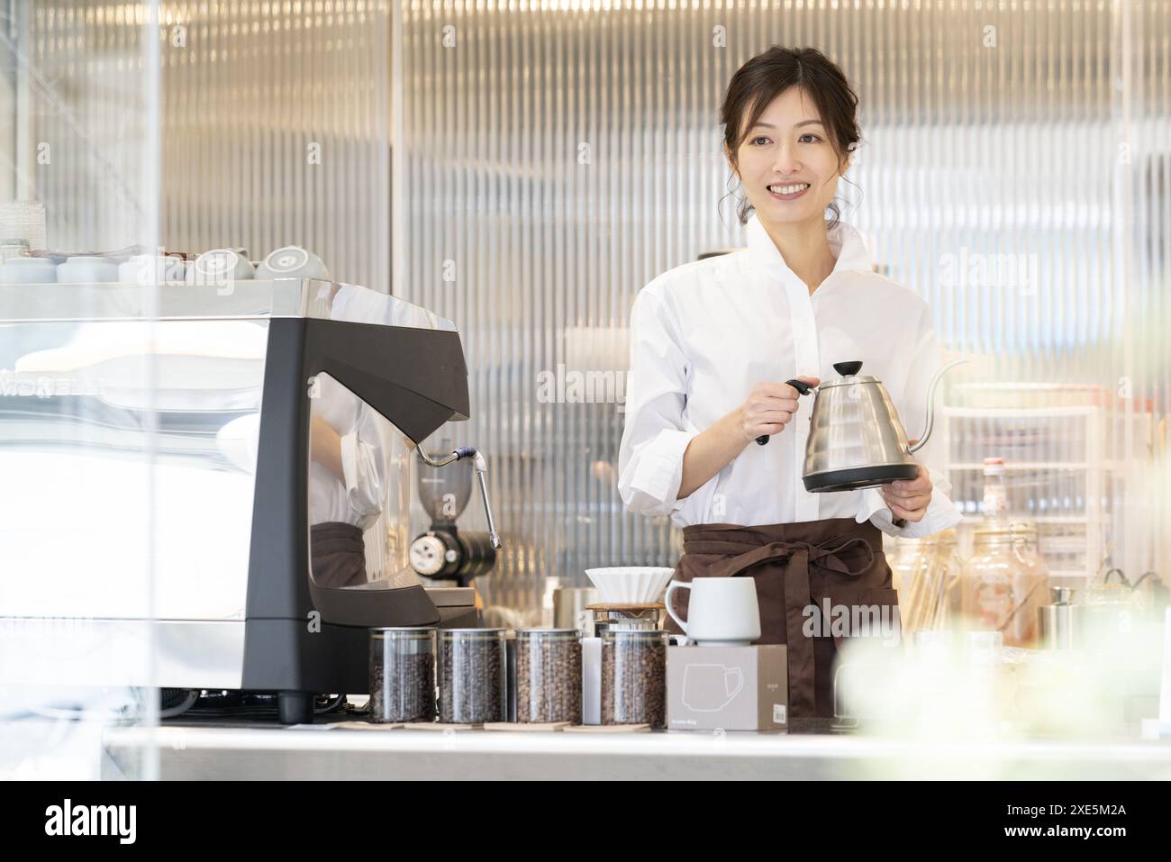 Femme dans le tablier travaillant dans le café Banque D'Images