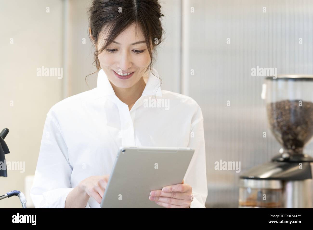 Femme utilisant une tablette dans un café Banque D'Images