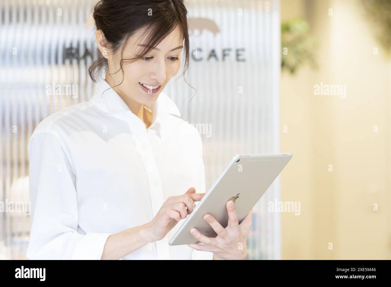 Femme utilisant une tablette dans un café Banque D'Images