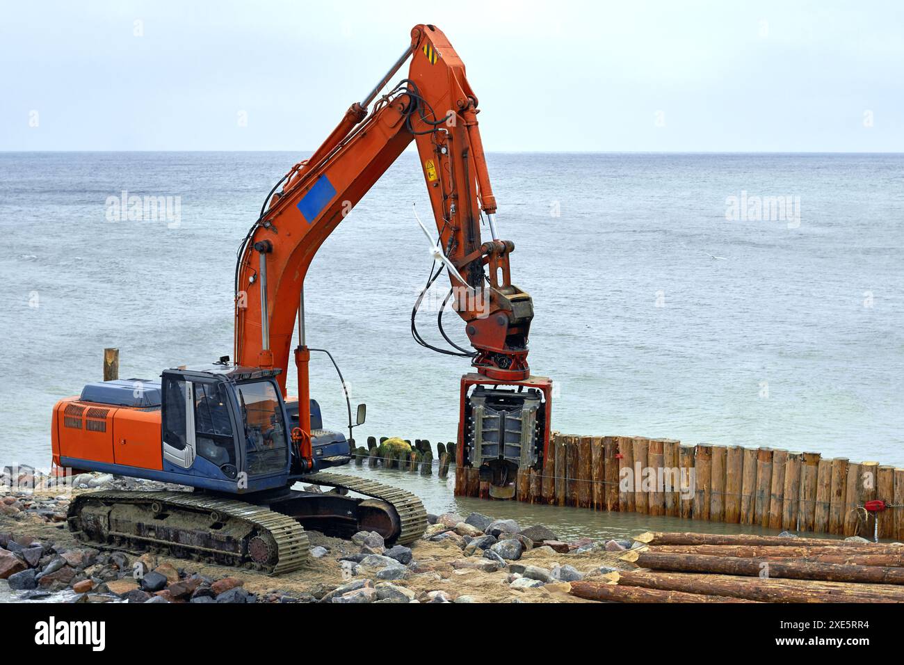 Machine de battage de pieux sur la plage sur le bord de mer. Travaux de stabilisation du littoral Banque D'Images
