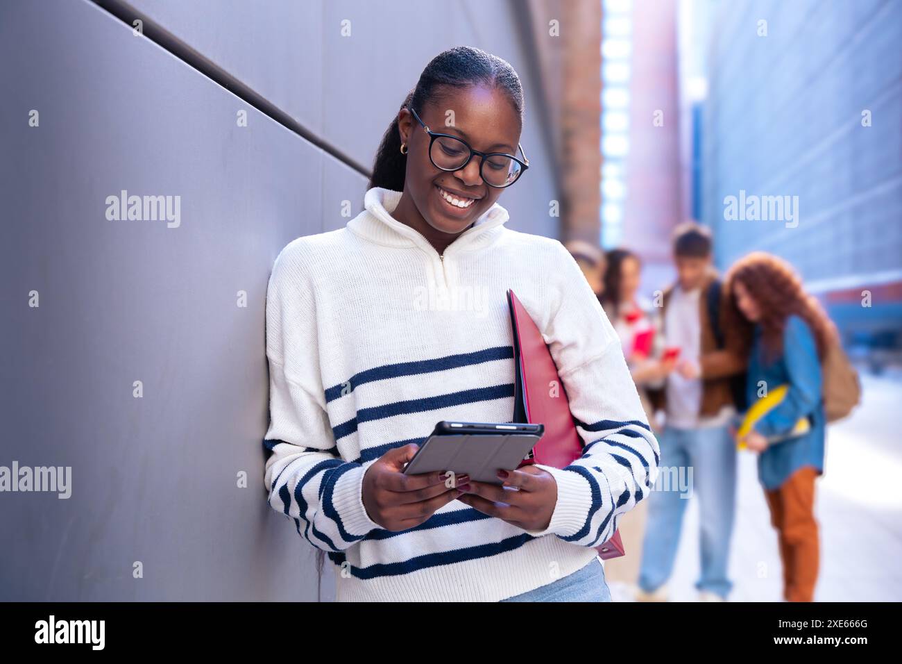Jeune femme afro-américaine naviguant sur Internet en utilisant un smartphone à l'extérieur. Banque D'Images
