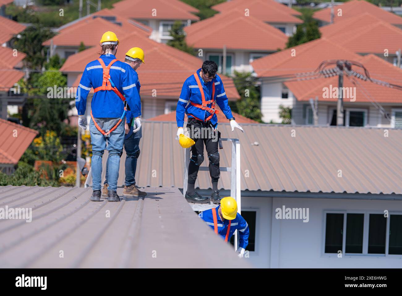 Après avoir installé et inspecté la performance des panneaux de cellules solaires sur le toit de l'usine, un groupe d'ingénieurs installant ainsi Banque D'Images