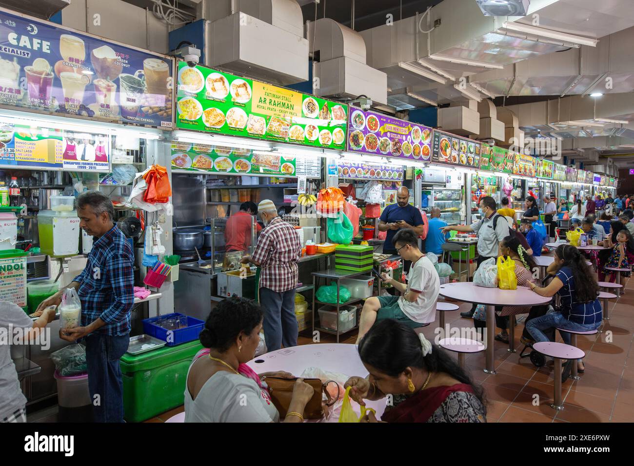 Juin 2024. Témoin de la culture des hawkers. Les gens attendent leur plat à emporter aux étals de hawkers du Tekka Market, Little India, Singapour. Banque D'Images