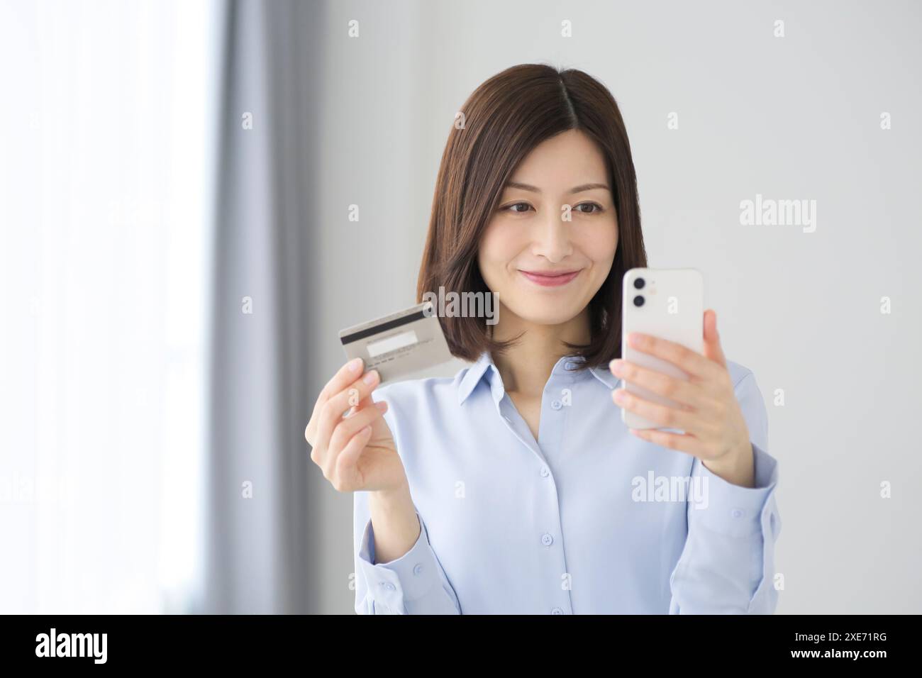 Femme avec smartphone et carte de crédit Banque D'Images