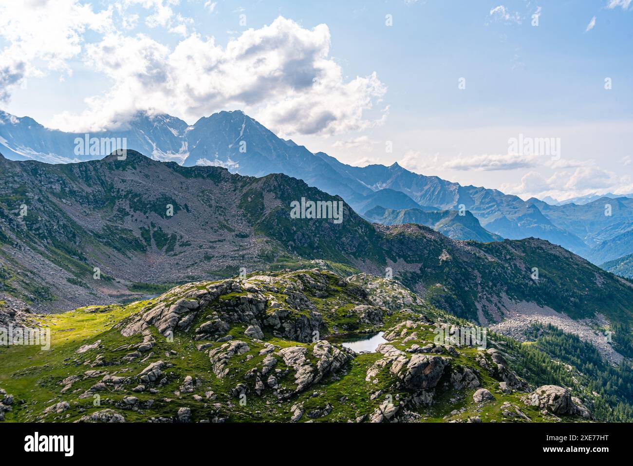 Prairie de montagne avec un lac sur un haut plateau et vue sur de hautes montagnes avec les sommets imposants des Alpes suisses à l'horizon, la Suisse, l'Europe Banque D'Images