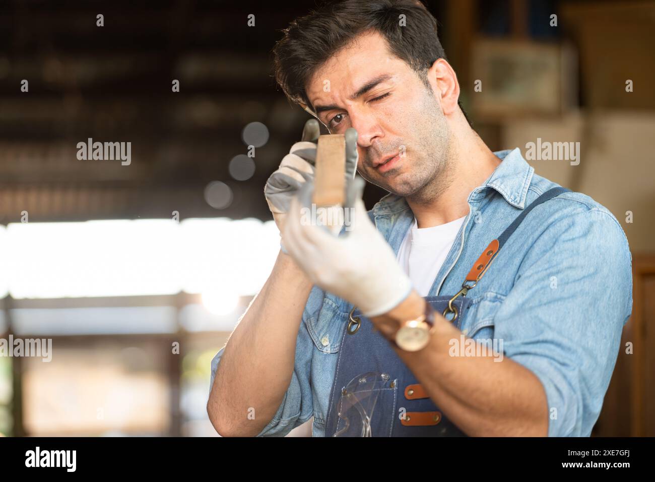 Menuisier travaillant dans son atelier de menuiserie. La vue est utilisée pour assurer la précision. Banque D'Images