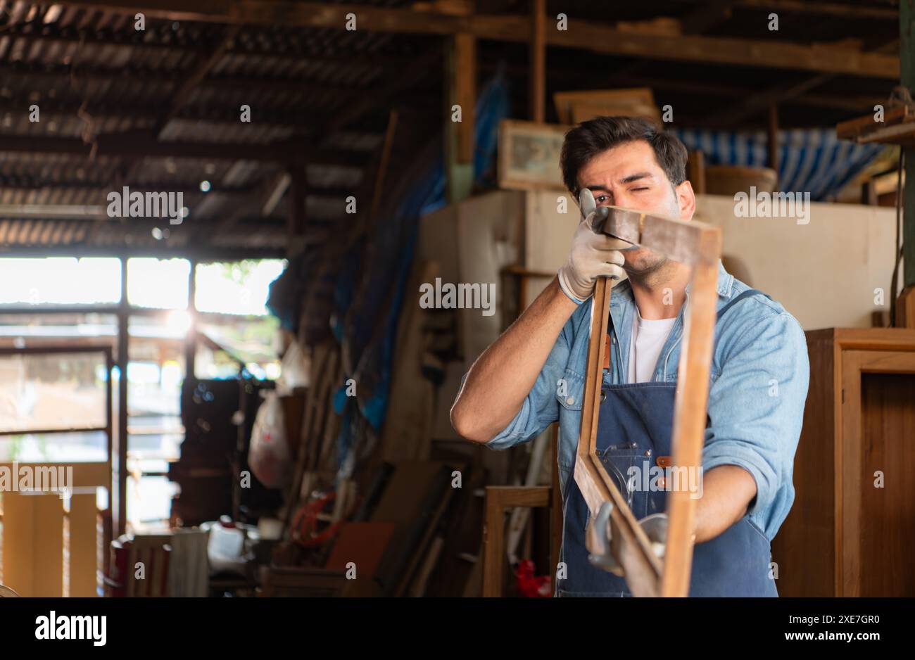 Menuisier travaillant dans son atelier de menuiserie. La vue est utilisée pour assurer la précision. Banque D'Images
