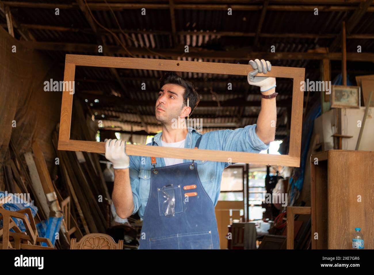 Menuisier travaillant dans son atelier de menuiserie. La vue est utilisée pour assurer la précision. Banque D'Images