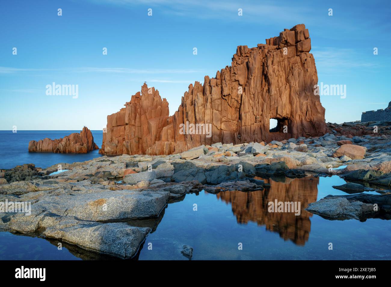 Vue des roches rouges d'Arbatax avec des reflets dans les bassins de marée au premier plan Banque D'Images