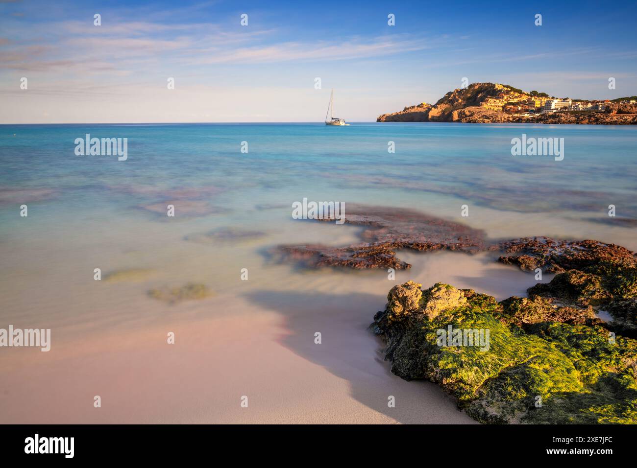 Vue sur la baie idyllique et la plage de Cala Agulla dans l'est de Majorque avec un voilier au premier plan Banque D'Images