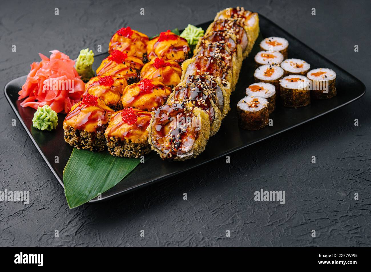 Sushis japonais assortis sur une assiette en pierre noire Banque D'Images
