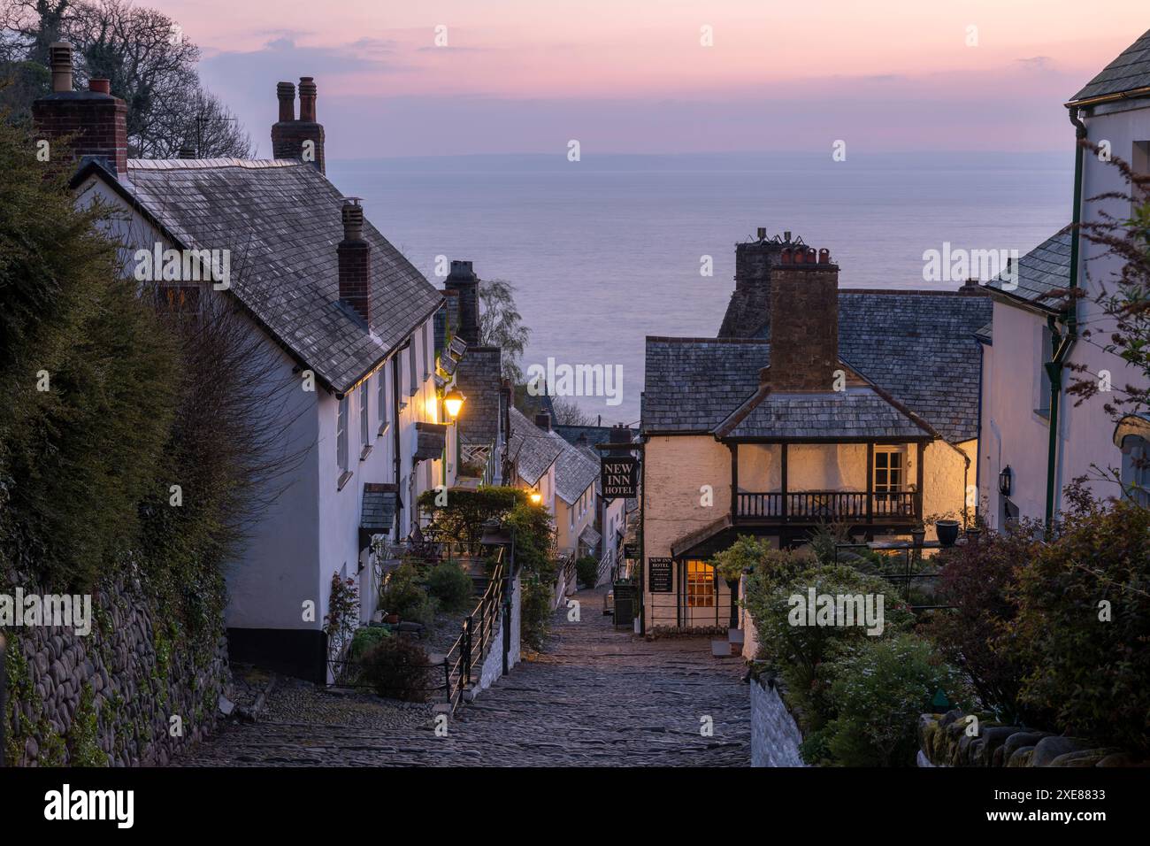 Ciel rose de l'aube au-dessus du joli village de Clovelly sur la côte nord du Devon, en Angleterre. Printemps (avril) 2019. Banque D'Images