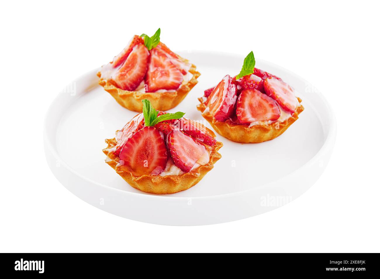 Tartelettes à la crème anglaise, fraises et menthe servies sur assiette blanche Banque D'Images