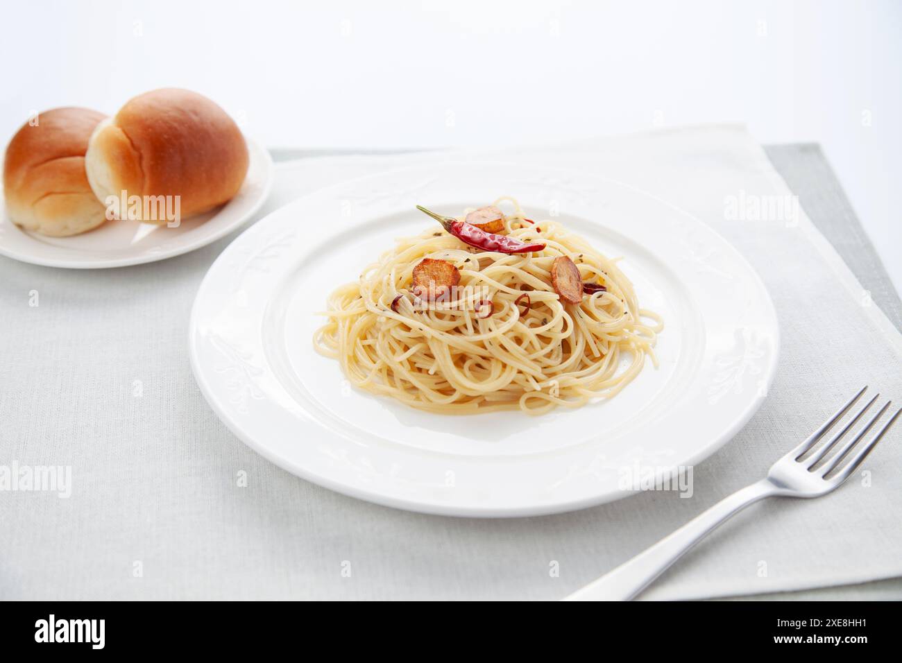 spaghetti aglio olio peperoncino avec du pain sur la table Banque D'Images