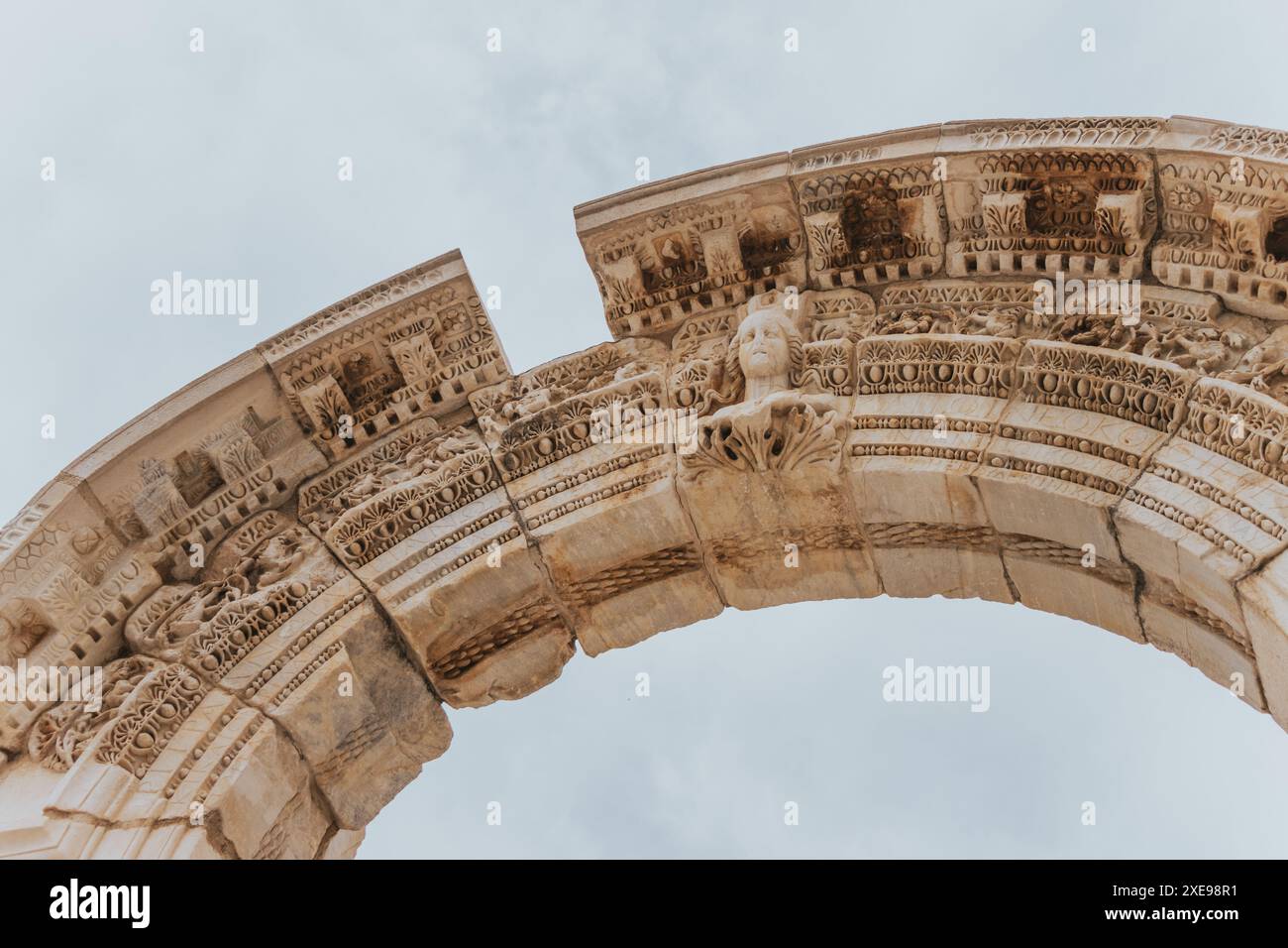 Une belle figure sculptée de Méduse sur une arche de pierre magnifique dans l'ancienne ville en ruine d'Ephèse à Türkiye par une journée nuageuse sans personne. Banque D'Images