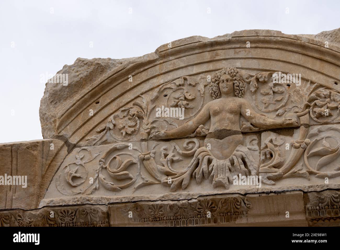Une belle figure sculptée de Méduse sur la façade d'un bâtiment dans l'ancienne ville en ruine d'Ephèse à Türkiye par un jour nuageux sans personne. Banque D'Images