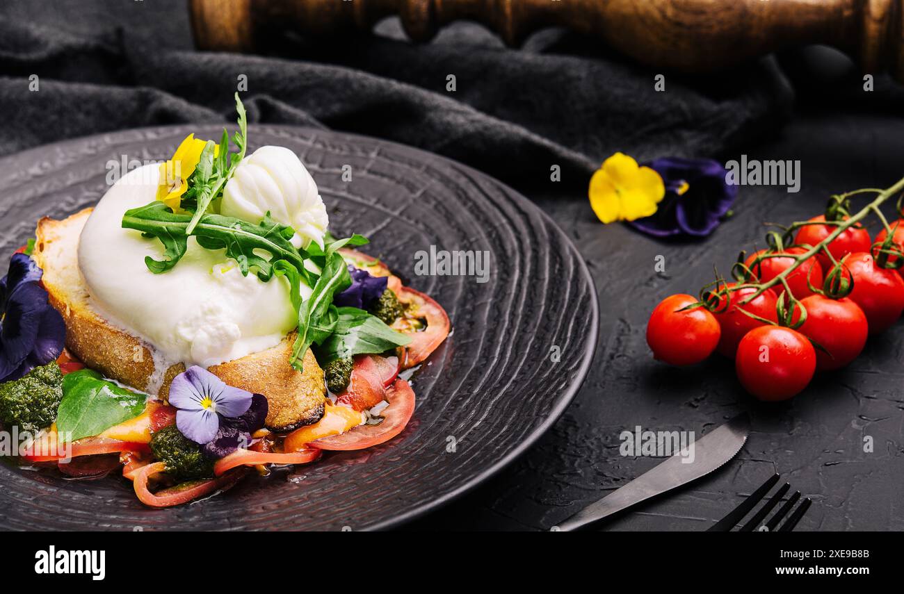 Fromage burrata de Buffalo servi avec pain grillé aux grains et légumes frais Banque D'Images